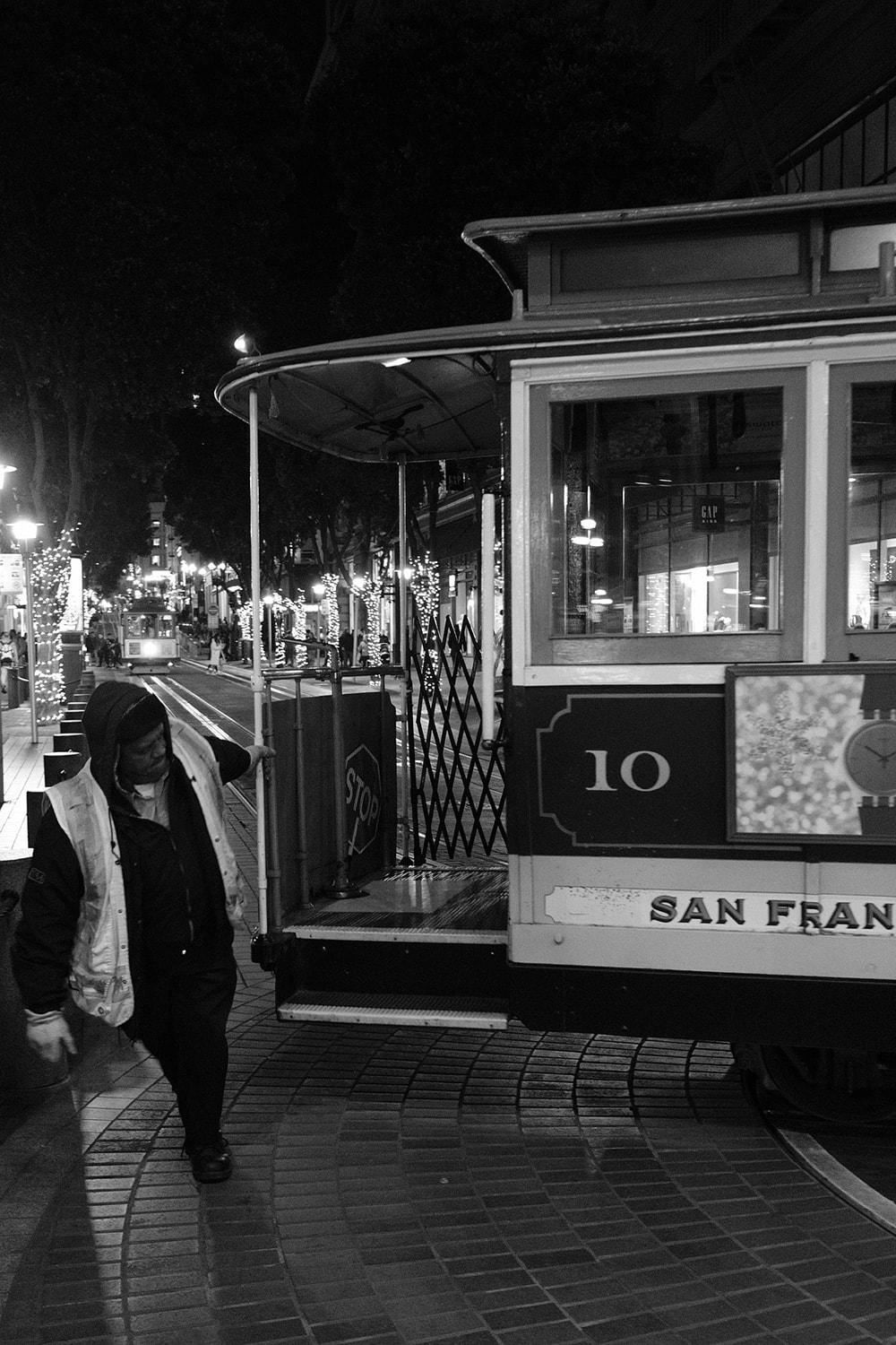 Black and white portrait photo of cable car conductor pulling a cable car on one of the mechanical turntables at the end of the line.